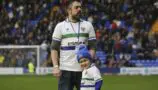 Phil and Nate in matching Tranmere Rovers jerseys standing on the football pitch